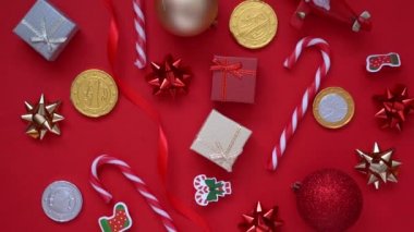 Noel arkaplanı. 4k Döndürme Videosu hediye kutusu, köknar ağacı dalları ve birçok Xmas çizgili şeker, kırmızı arka planda kırmızı şenlik süslemeleri. Noel ve yeni yıl tatili konsepti