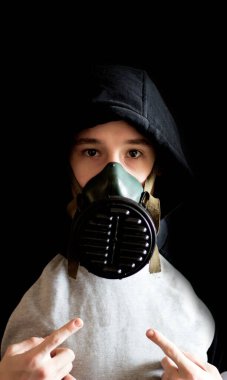 Siyah arka planda gaz maskeli bir genç.