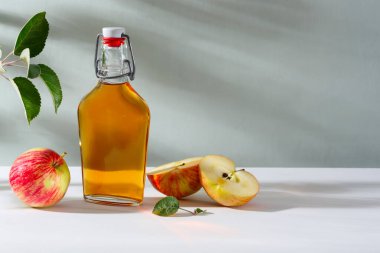 Taze elmalar ve elma sirkesi. Cam şişede elma şarabı ve taze elmalar. Hafif arkaplan.