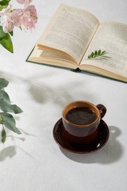 Beyaz bir masanın üzerindeki fincanda taze aromatik kahve. Hafif arkaplan.