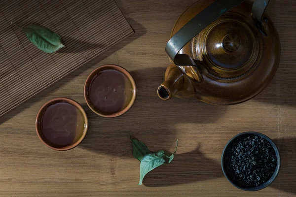 Asian tea set and tea leaves on a wooden table. Top view.