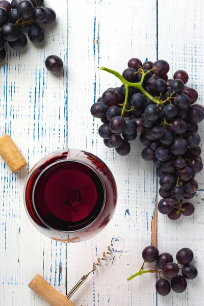 red wine and grapes. Wine and grapes in vintage setting with corks on wooden table