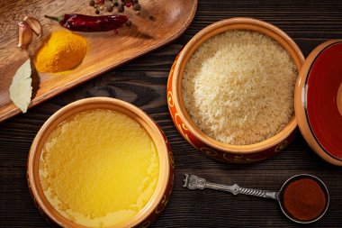 Ev yapımı ghee, seramik kapta pilav, kırmızı biber ve zerdeçal baharatları. Üst görünüm.