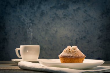 Ev yapımı taze kekler üzerine krema serpiştirilmiş şeker ve beyaz bir masanın üzerine taze kahve serpiştirilmiş. Lezzetli ve sağlıklı kahvaltı.. 