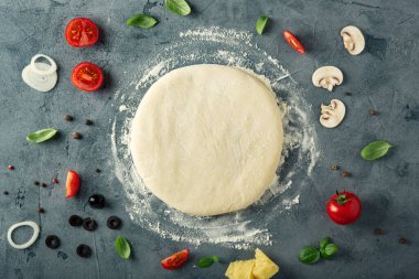 Masada ev yapımı pizza için malzeme ve hamur var. Üst görünüm.