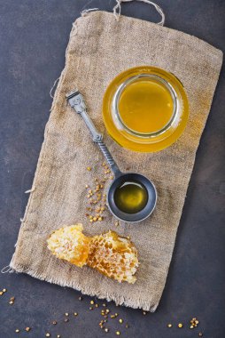 Bal geçmişi. Tarakta tatlı bal, cam kavanoz. Ahşap arka planda. Üst görünüm