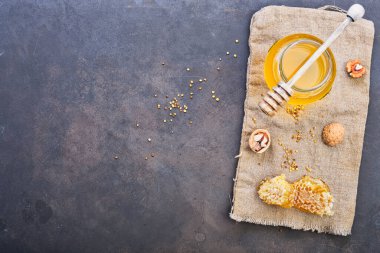 Bal geçmişi. Tarakta tatlı bal, cam kavanoz. Ahşap arka planda. Üst görünüm