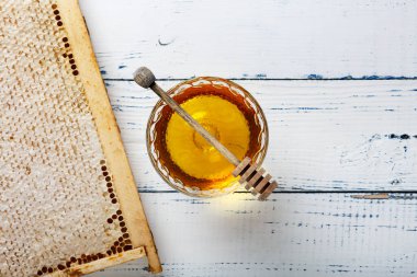 Bal geçmişi. Tarakta tatlı bal, cam kavanoz. Ahşap arka planda. Üst görünüm.