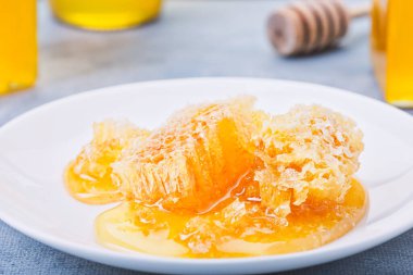 Bal geçmişi. Tarakta tatlı bal, cam kavanoz. Ahşap arka planda