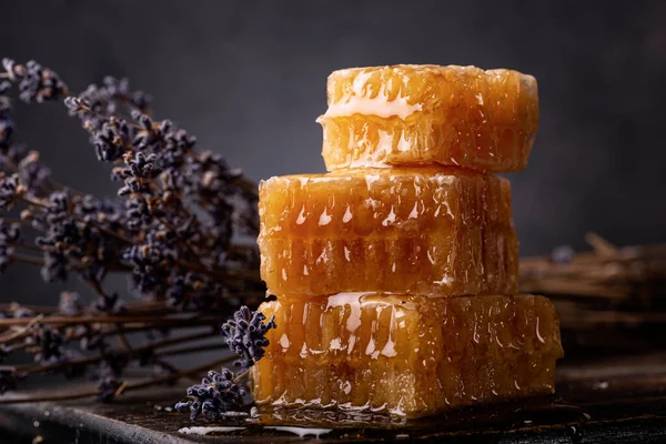 Bal geçmişi. Tatlı bal tarağı ve lavanta rengi yakın plan. Koyu arkaplan.