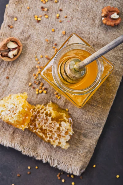Honey background. Sweet honey in the comb, glass jar. On wooden background. Top view