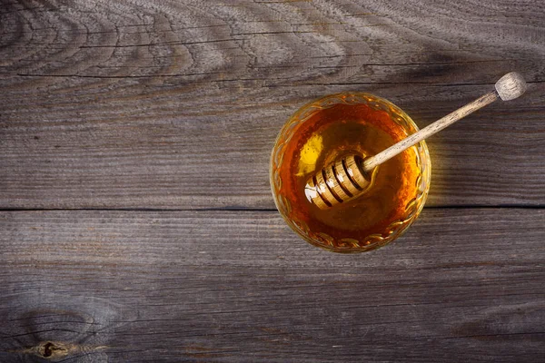Honey background. Sweet honey in the comb, glass jar. On wooden background. Top view.