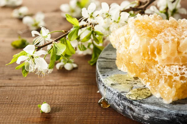 Bal geçmişi. Tahta masanın üzerinde bal kovanı olan bal.