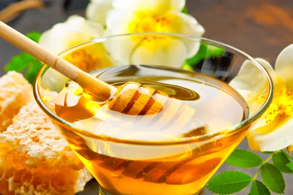 Bal geçmişi. Tahta masanın üzerinde bal kovanı olan bal.