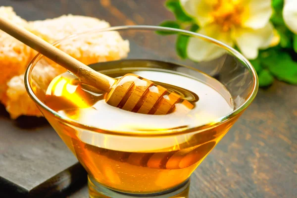 Honey background. Honey with wooden honey dipper on wooden table