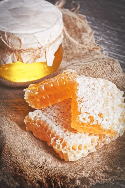 Bal geçmişi. Tahta masanın üzerinde bal kovanı olan bal.