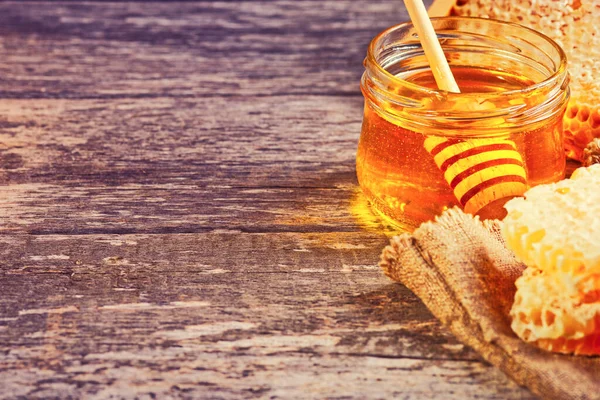 Honey background. Honey with wooden honey dipper on wooden table