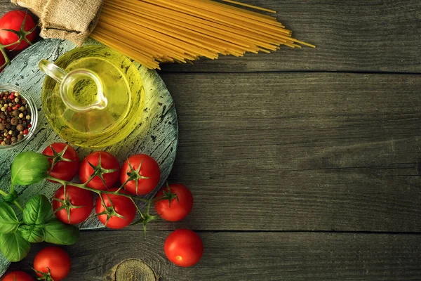 Siyah arka planda İtalyan yemekleri için makarna, sebze, bitki ve baharat, üst manzara, kopyalama alanı