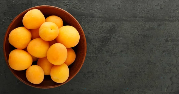 Ahşap arka planda olgun kayısılar ve kayısı yaprakları.