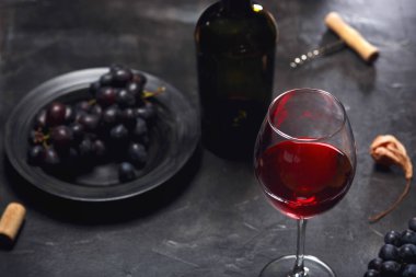 Kırmızı şarap ve üzüm. Şarap ve üzümler, ahşap masa mantarlı eski usul. Üst görünüm