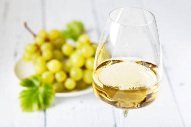 Eski ahşap masada bir bardak beyaz şarap. Hafif arkaplan