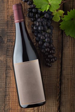 Etiketli bir şişe kırmızı şarap. Bir bardak şarap ve mantar. Şarap şişesi maketi. Üst görünüm.