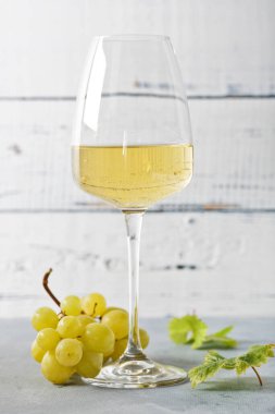 Eski ahşap masada bir bardak beyaz şarap. Hafif arkaplan