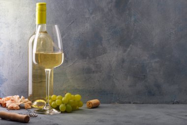 Eski ahşap masada bir kadeh beyaz şarap.