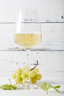 Eski ahşap masada bir bardak beyaz şarap. Hafif arkaplan