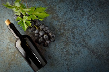 Taze sulu üzümler, bir şişe kırmızı şarap ve üstteki yazı için yer.