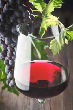 Kırmızı şarap ve üzüm. Şarap ve üzümler, ahşap masa mantarlı eski usul.