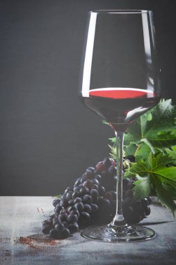 Kırmızı şarap ve üzüm. Şarap ve üzümler, ahşap masa mantarlı eski usul.