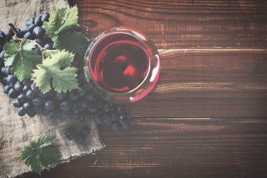 Kırmızı şarap ve üzüm. Şarap ve üzümler, ahşap masa mantarlı eski usul.