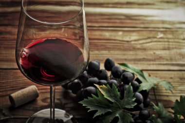 Kırmızı şarap ve üzüm. Şarap ve üzümler, ahşap masa mantarlı eski usul.