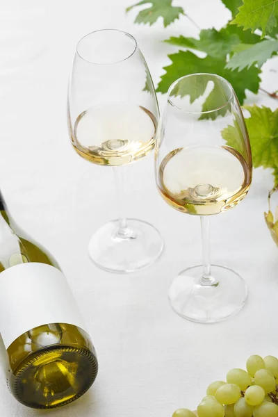 Weißwein Gläsern Eine Flasche Trauben Und Traubenblätter Auf Dem Tisch — Stockfoto