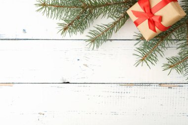 Hediye kutulu Noel arkaplanı. Hediye kutusu ve ladin dalı ahşap bir masada. Mutlu Noeller ve mutlu yıllar. Üst görünüm.