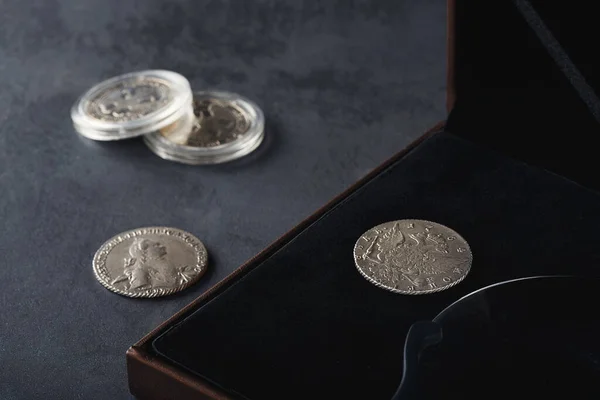 Numismatikler. Tahta bir masanın üzerinde gümüş, altın ve bakırdan yapılmış eski koleksiyon paraları..