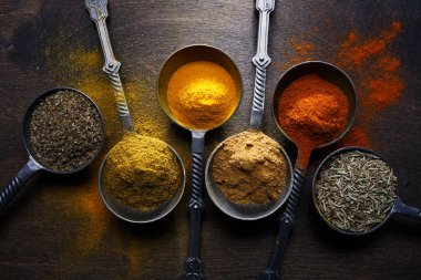 Renkli baharatlardan oluşan ahşap bir masa. Üst Manzara. Koyu arkaplan.