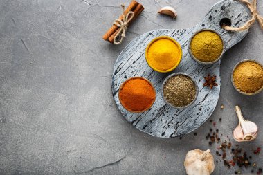 Ahşap masada çeşitli rengarenk baharatlar, üst manzara.