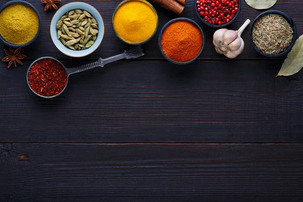 Renkli baharatlardan oluşan ahşap bir masa. Üst görünüm