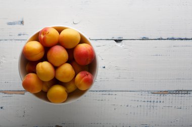 Seramik kasede taze kayısılar, yakın plan. Üst görünüm.