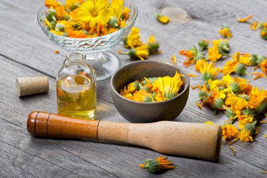 Calendula. Ahşap arka planda Marigold çiçek yaprağı üst görünümü. Calendula fincanı (Marigold çiçeği) yaprak doğal yaz çiçeği. Calendula officinalis tıbbi bitki yaprakları ve bitki yaprakları - sağlıklı konsept