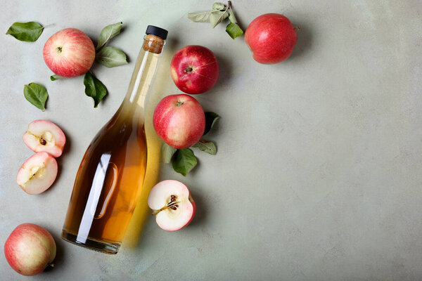 Apple cider vinegar and fresh apples, flat lay, space for your text. Top view