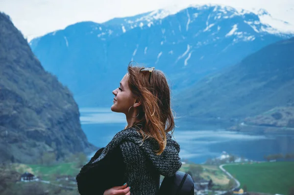 Mladá žena stojí na pozadí krásných hor a jezera — Stock fotografie