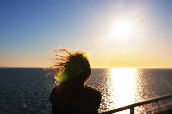 Красивая девушка смотрела с восторгом на море и небо на закате — стоковое фото