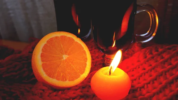 Mulled wine in glass mugs, burning candle on a dark red background. Red Hot wine — Stock Photo, Image