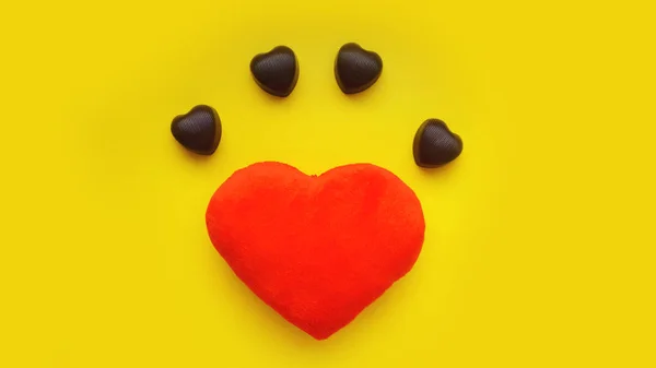 Valentinky den pozadí Plyšová hračka srdcem a čokoláda na žlutém podkladu — Stock fotografie