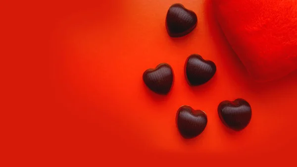 Φόντο ημέρα του Αγίου Βαλεντίνου με την καρδιά μαλακό παιχνίδι και σοκολάτες σε κόκκινο φόντο — Φωτογραφία Αρχείου