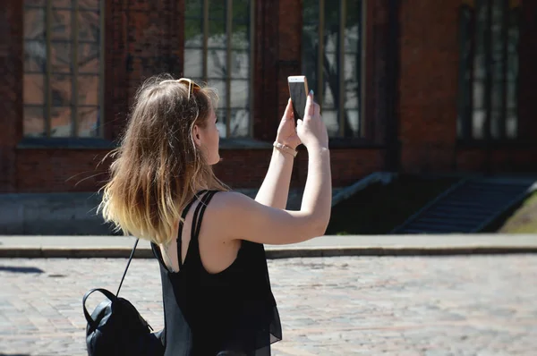 Menina jovem tirando fotos da cidade com telefone inteligente móvel — Fotografia de Stock