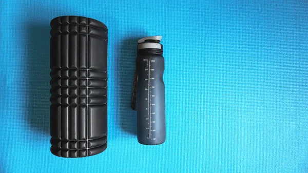 Foam Roller with water bottle Gym Fitness Equipment Blue background self Myofascial Release - MFR. — Stock Image Foam Roller Water Bottle Gym Fitness Equipment Blue Background Self Stock Photo